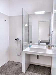 雅典Brand new budget apartment next to Iaso and Oaka的白色的浴室设有水槽和淋浴。