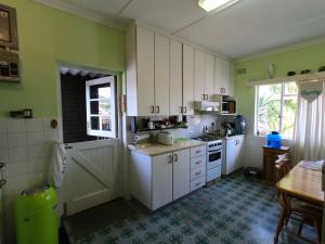钓鱼镇Leo's Den的厨房设有绿色的墙壁和白色的橱柜。