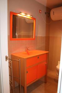 塞维利亚CLB Feria Apartment的浴室设有橙色水槽和镜子