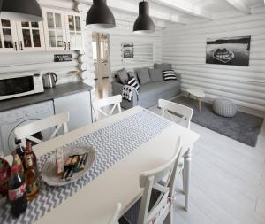 奥巴曹洛克Öböl Liget vendégházak的厨房以及带白色桌椅的起居室。