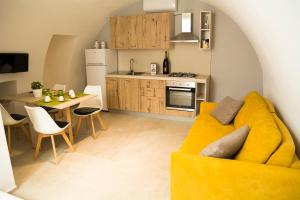安德里亚Borgorosa Dimora In Puglia的一间带黄色沙发的客厅和一间厨房