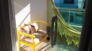 阿拉亚尔-杜卡布Casa da Celia的阳台的黄色椅子和吊床