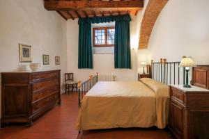 卡莱扎诺索马亚农家乐的一间卧室配有一张带绿色窗帘的床和窗户。
