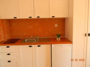 科帕罗Villa Kostandin的厨房配有白色橱柜和水槽