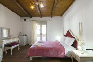 扎罗斯Zaros的一间卧室配有一张带红色毯子的大床