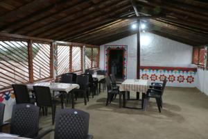 BherandiālaBanni Village Stay的一间在房间内配有桌椅的餐厅