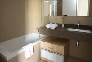 巴塞罗那MH套房公寓式酒店的浴室配有盥洗盆和浴缸。