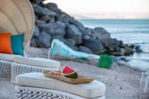 提比里亚加里利海畔加里利海U精品酒店的海滩上椅子上的碗里一片西瓜