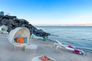 提比里亚加里利海畔加里利海U精品酒店的海滩上设有椅子、帐篷和水