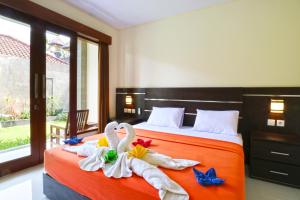 勒吉安Gempita House Bali的两个天鹅坐在卧室的床上