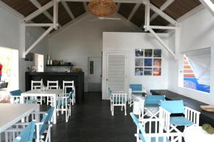 Rodrigues Island巴库瓦山林小屋的用餐室配有白色的桌子和蓝色的椅子