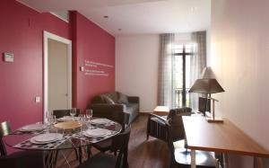 巴塞罗那MH套房公寓式酒店的一间带桌子的用餐室和一间客厅