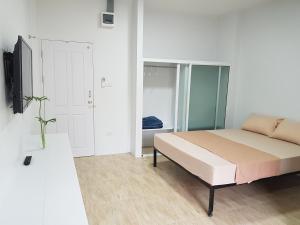 曼谷Prukpibul Apartment的一间卧室配有一张床和一台电视。