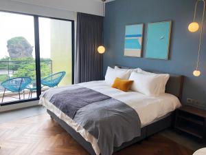 鹅銮鼻美好生活旅店的一间带大床的卧室和一个阳台