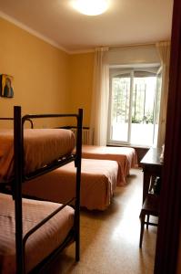 阿西西奇塔代拉奥斯普酒店的一间卧室设有三张双层床和一扇窗户。