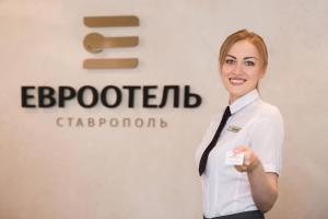 斯塔夫罗波尔斯塔夫罗波尔欧洲酒店的持卡的白衬衫和领带的女人
