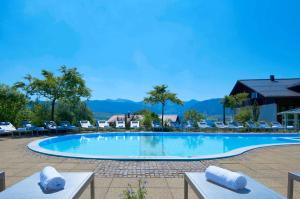 上施陶芬阿尔高阳光酒店的一座带椅子和山脉的大型游泳池