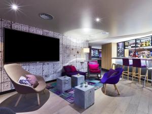 尼斯钟楼尼斯机场酒店的客厅配有紫色椅子和平面电视