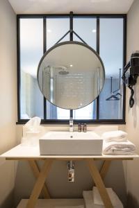 阿卡雄T Boutique Hotel的一间带水槽和大镜子的浴室