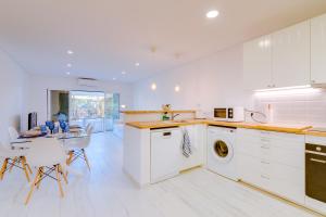 韦尔都勒博Villa V1 Vale do Lobo Beach的厨房配有白色橱柜和桌椅