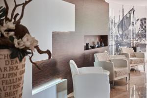 马尔切西内斯梅拉尔达别墅酒店的一间设有白色椅子和壁炉的等候室