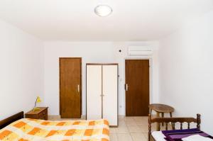 莫鲁纳特Villa Peragic的卧室配有1张床、1张桌子和1把椅子