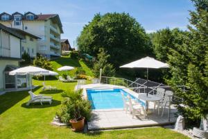 法克湖畔杜罗博拉赫Haus Panorama的后院设有游泳池、椅子和遮阳伞