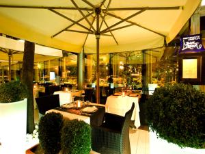 佩萨罗萨伏依酒店的一间餐厅,配有桌椅,位于伞下