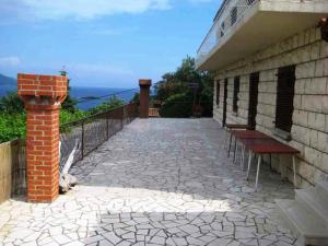莫鲁纳特Villa Peragic的石头人行道,建筑的一侧设有长凳