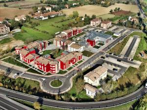 马拉内罗Hotel Maranello Village的享有红色建筑和道路的城市空中景观