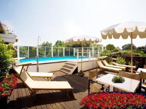 佩萨罗萨伏依酒店的一个带桌椅的庭院和一个游泳池