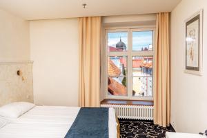 塔林美利通旧城伽登酒店的一间卧室设有一张床和一个大窗户