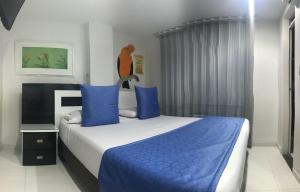 比亚维森西奥Hotel Bahia的一间卧室配有一张带蓝色枕头的大床
