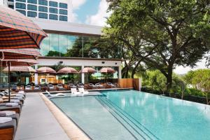 奥斯汀奥斯汀丽尼酒店的一个带躺椅的游泳池和一间酒店