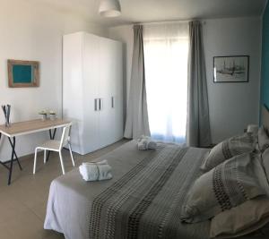 圣泰雷萨迪里瓦Appartamento Gambero Beach的一间卧室配有一张床、一张桌子和一个窗户。