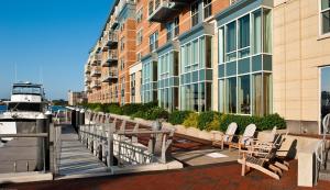 波士顿波士顿滨水区巴特利码头酒店的坐在建筑物旁边的码头上的一排椅子