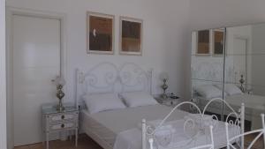 KariáEstate Dafnopanagia Luxury Apartment Ourania的白色卧室配有床和镜子
