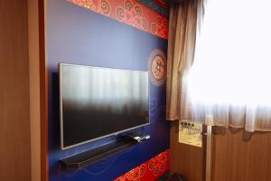 台南蒙娜丽莎商务旅馆的挂在蓝色墙壁上的平面电视