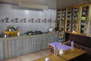 PemayangtseVamoose Chungdah Homestay的厨房配有木制橱柜和桌子。
