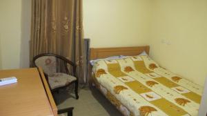 耶路撒冷棕榈旅馆的卧室配有1张床、1张桌子和1把椅子
