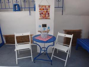 卡尔扎迈纳艾姆菲公寓的两把椅子和一张桌子,一张桌子和一张蓝色的桌子和椅子