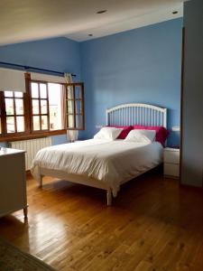 桑提亚纳德玛Posada Adela的蓝色卧室配有白色的床和红色枕头