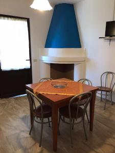 吉拉索莱Appartamenti Alessio的一张带椅子的餐桌和蓝色的天花板