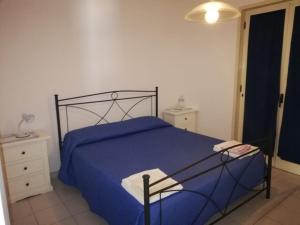 圣卡特琳娜迪纳德La Scogliera的一间卧室配有一张带蓝色床罩的床