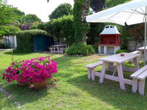 卡尼奥提Asteras hotel的院子里的野餐桌、长凳和鲜花