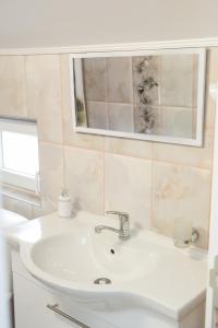 索科矿泉村Apartmani "ROSHU"的浴室设有白色水槽和镜子