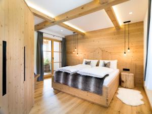 圣坎迪朵Chalet Novalis的一间卧室设有一张大床和木墙