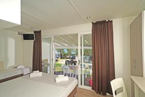 托里德尔贝纳科Camping Spiaggia D' Oro Torri的一间卧室设有两张床,享有庭院的景色