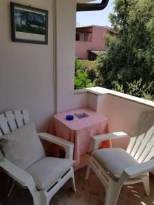 罗通多港Bed and Breakfast da Gigi e Antonella的庭院设有两把椅子、一张桌子和一扇窗户。