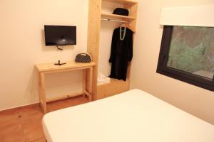 佩弗卡里Eva 's Paradise的一间小卧室,配有一张床和电视